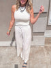 Flowy and lightweight khaki palazzo pants shown in motion, styled with neutral tones and studded slides for effortless style.