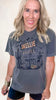 Vintage-style Halloween tee with Skellie Motel print featuring skeletons, pumpkins, and bats.