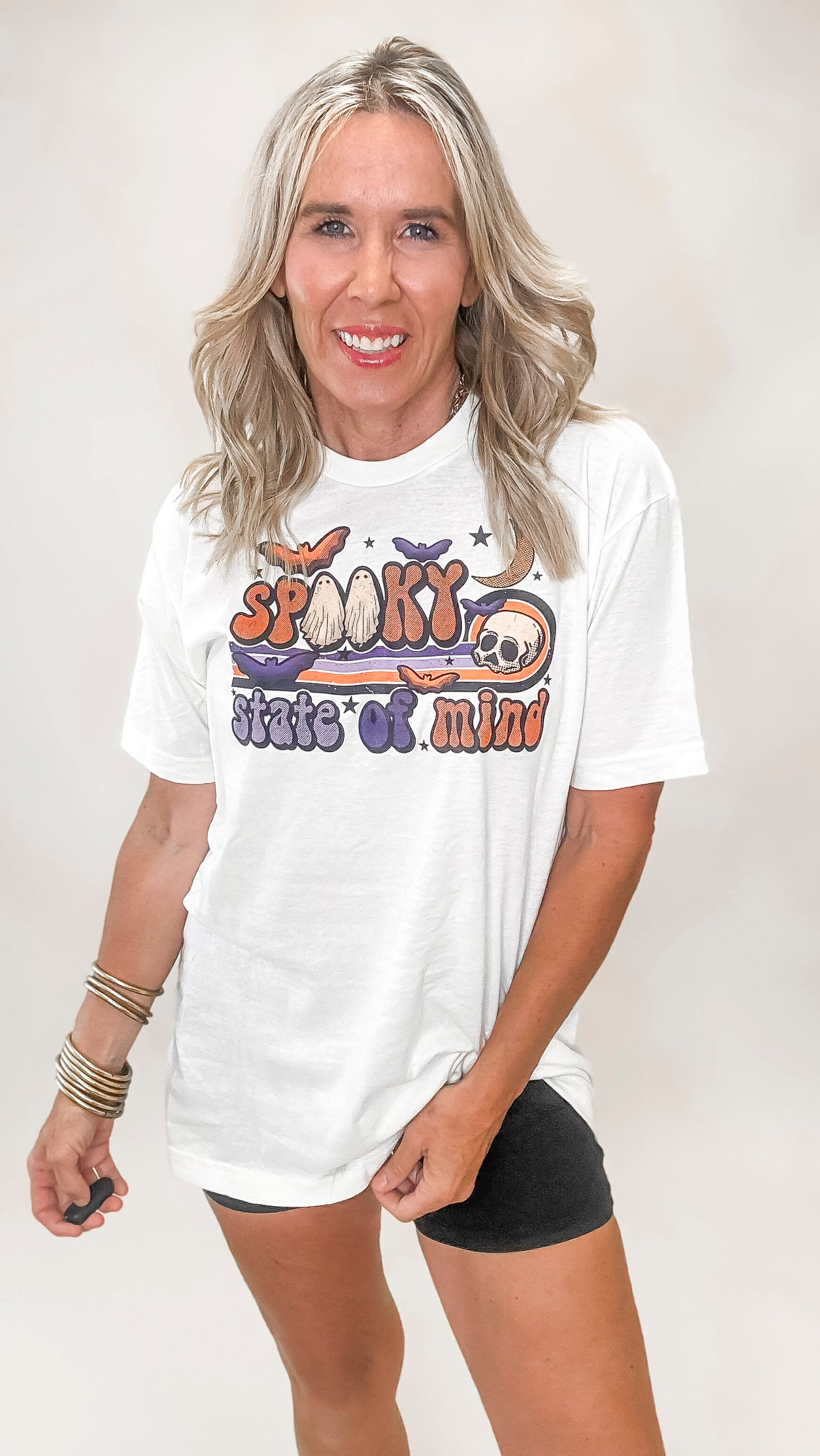 Ivory graphic tee with colorful 'Spooky State of Mind' print featuring ghosts, bats, a skull, and stars
