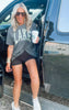Faded black unisex t-shirt featuring camouflage 'LAKE' print design.