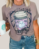 Person wearing a graphic t-shirt with a coffee cup design, holding a Starbucks cup.