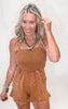 Woman wearing a brown romper with a plain background