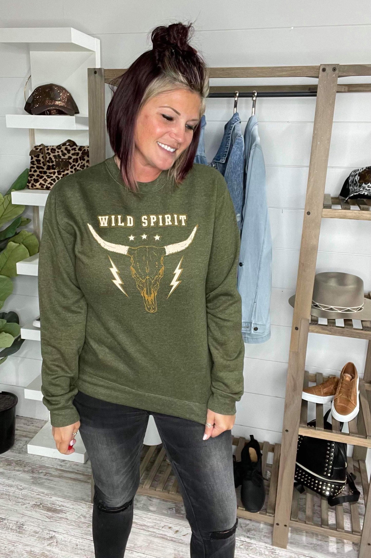 long sleeve olive unisex sweatshirt with the graphic Wild Spirit and bull skull image